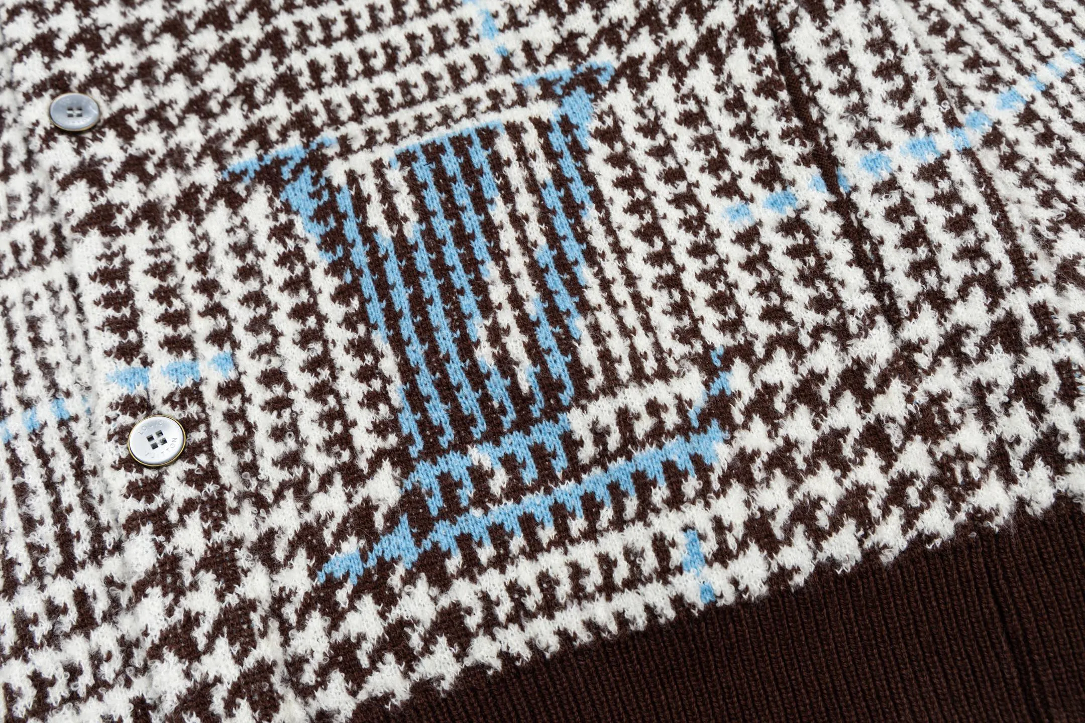 🅿️570 1v 26SS houndstooth letter intarsia V-neck knitted cardigan. The original version was purchased for 14,743 and developed. The fabric is made of yarn fabric made of 69% sheep wool blended with 31% nylon. The main pattern is woven with a full-width jacquard process, which interweaves the houndstooth pattern with light blue line texture. At the same time, the brand logo elements are integrated into the body through the intarsia process, and the edges of the pattern are connected delicately and seamlessly. The collar, cuffs and hem are made of 100% sheep wool ribbed fabric, and are edged with double-needle seaming technology, which has both elasticity and shaping effect. The front placket is equipped with natural-textured buttons, and the side seam pockets use invisible stitching technology to blend naturally with the jacquard texture of the body. The overall shape is shaped through three-dimensional tailoring, and the shoulders are stitched with seamless stitching to ensure fit and comfort. The entire piece is finished with handcrafted details in an Italian workshop, showing the craftsmanship precision of high-quality knitted items. The overall wiring is straight and delicate, the fabric is comfortable and soft, and the color is consistent without color difference. It can be matched with the same style to create a fashionable look and control various occasions. Customized accessories, complete with three standards, the same style for men and women. Size:S-M-L-XL
